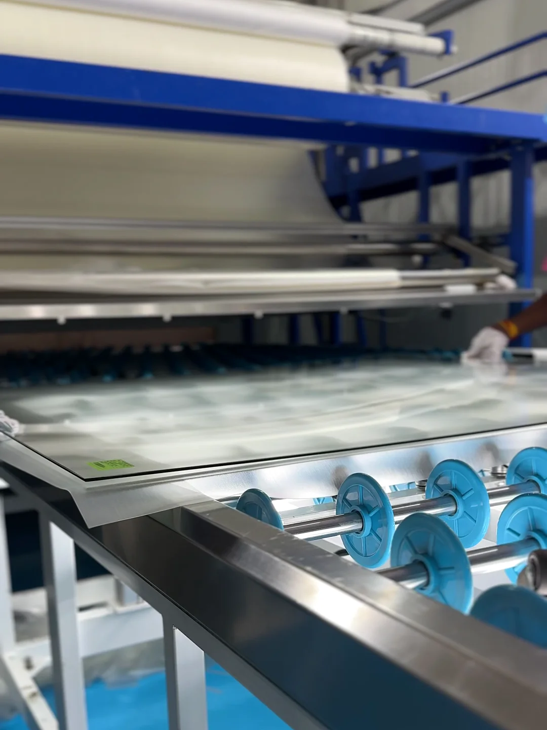 A sheet on the lay-up rollers of ARG's jumbo lamination line, the interlayer roll above it